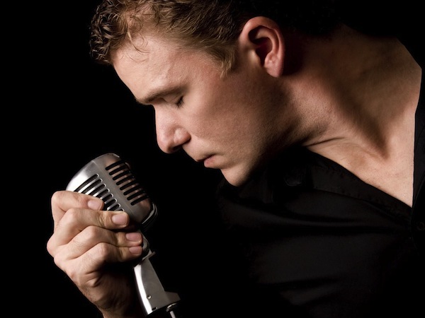 portrait of young musician holding his microphone